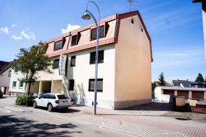 菲尔恩海姆AP Hotel Mannheim Viernheim am Kapellenberg的一栋建筑前停着一辆车