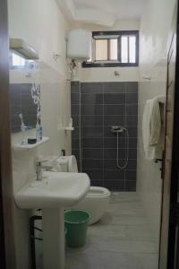 une salle de bain avec un lavabo et des toilettes dans l'établissement Appartement entier proche de la plage Yoff BCEAO A2, à Dakar