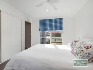 um quarto com uma grande cama branca e uma janela em Ode to Glittering Bay em Blairgowrie
