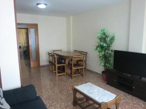 a living room with a table and chairs and a tv at Piso La Pista Alcora in Alcora