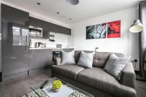 ein Wohnzimmer mit einem Sofa und einer Küche in der Unterkunft *Liverpool City Centre Modern Stylish Apartment in Liverpool