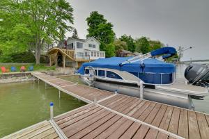 un barco azul y blanco está atracado en un muelle en Family-Friendly Cayuga Lake Retreat with Dock!, en Seneca Falls