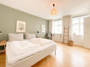 1 cama blanca grande en una habitación con ventanas en Large Flat with 4 Bedrooms in Copenhagen en Copenhague
