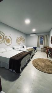 um quarto com três camas e um tapete em Recanto da Barra Chalé em Barra Grande