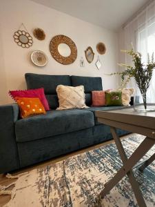 a living room with a blue couch with colorful pillows at Vivienda Oasis Feria in Albacete