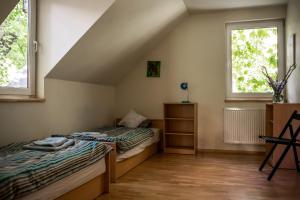 twee bedden in een kamer met twee ramen bij Cottage house Lublin in Lublin +59 foto's