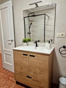 a bathroom with a sink and a mirror at Piso en Jarandilla de la Vera in Jarandilla de la Vera