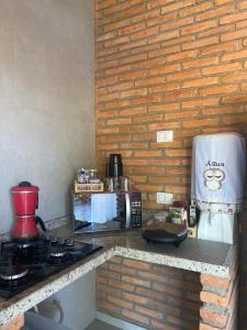 y cocina con encimera, fogones y microondas. en Recanto da Barra Chalé, en Barra Grande