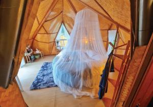 ein Schlafzimmer in einer Jurte mit einem Moskitonetz in der Unterkunft Dao Bon Din Camping 