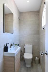 馬斯帕洛馬斯的住宿－Duplex Los Tinos II 32 by VillaGranCanaria，浴室配有白色卫生间和盥洗盆。