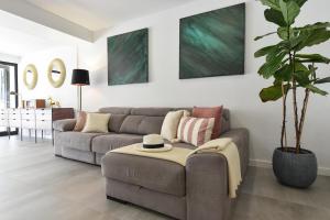 a living room with a couch and a plant at Duplex Los Tinos II 32 by VillaGranCanaria in Maspalomas