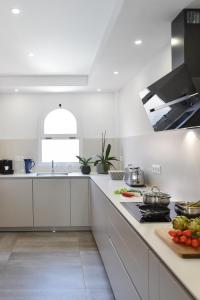 uma cozinha com armários brancos e uma bancada em Duplex Los Tinos II 32 by VillaGranCanaria em Maspalomas