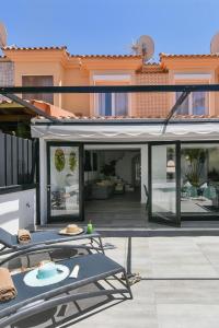 una casa con patio con mesa y sillas en Duplex Los Tinos II 32 by VillaGranCanaria, en Maspalomas