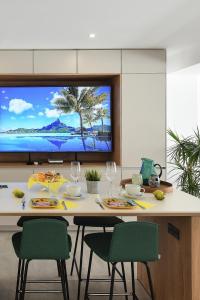 a kitchen with a table with chairs and a tv at Duplex Los Tinos II 32 by VillaGranCanaria in Maspalomas