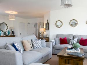 a living room with two couches and a table at Pass the Keys Beautiful 3 bedroom apartment with Pool Access in Trearddur
