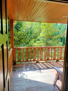 a wooden porch with a bench on a deck at Family Resort in Baan Tai
