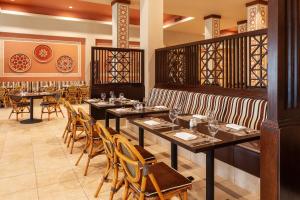 une salle à manger avec de longues tables et chaises dans l'établissement Jaz Tamerina, Almaza Bay, à Marsa Matruh