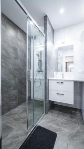 a bathroom with a glass shower and a sink at Apartment Le Château in Radom