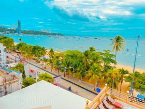 uma vista para uma praia com palmeiras e para o oceano em AA Hotel Pattaya em Pattaya Central