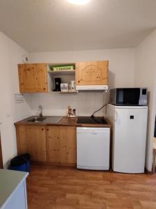 a small kitchen with a refrigerator and a microwave at Orelle 3 Vallées - Studio 4 personnes in Orelle