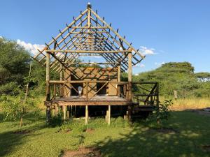 a wooden structure sitting on top of a field at Lorato Lodge and Camping in Muchenje
