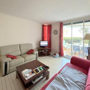 un soggiorno con divano e tavolo di Joli appartement face au port, accès direct plage 4RP17 a Le Barcarès