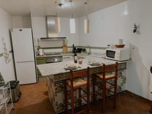 a kitchen with a microwave and a counter with stools at La Casa de la Acacia in Olba +28 photos