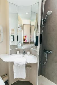 a bathroom with a sink and a shower at Kyriad Metz Centre - Restaurant Moze in Metz +53 photos