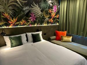 a bedroom with two beds with colorful pillows at Rugs Hotel Augsburg City in Augsburg