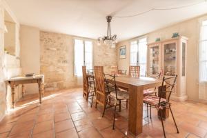 uma sala de jantar com uma mesa de madeira e cadeiras em La Célestine - Belle maison en pierre de 250m2 avec jardin em Mudaison