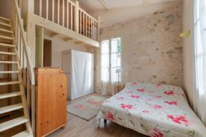 um quarto com uma cama e uma escada de madeira em La Célestine - Belle maison en pierre de 250m2 avec jardin em Mudaison