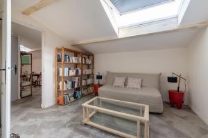 uma sala de estar com uma cama e uma estante de livros em La Célestine - Belle maison en pierre de 250m2 avec jardin em Mudaison