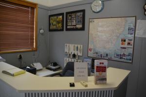 
a desk with a monitor, keyboard, and other items at Adrian Motel in Forbes
