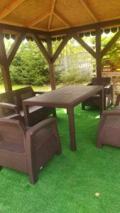 una mesa de picnic y sillas sobre hierba bajo un cenador en Ostoja Jarząbka 