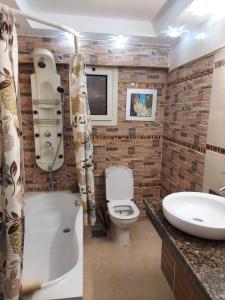 uma casa de banho com um lavatório, um WC e uma banheira em Alnakheel apartment near cairo Festival no Cairo