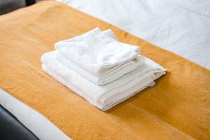 a stack of white towels sitting on a table at Modern private Double en-suite room2 in Barkingside