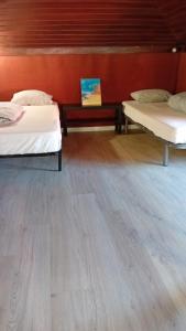 a room with two beds and a wooden floor at Beach House São Pedro in São Pedro do Estoril