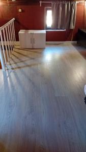 an empty living room with a large wooden floor at Beach House São Pedro in São Pedro do Estoril