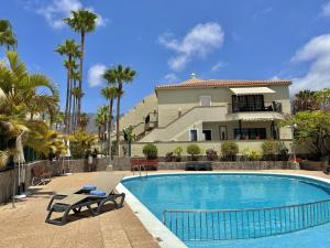 a house with a swimming pool in front of a house at Duque Beachside Elegance in Adeje