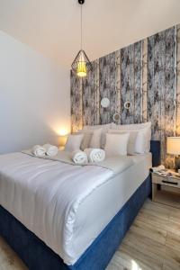 1 dormitorio con cama blanca y pared de madera en Absyntapart Stare Miasto, en Wroclaw