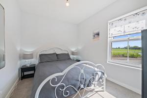 ハイブリッジにあるSpacious Holiday Home Somersetのベッドと窓のある白い寝室