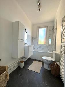 La salle de bains est pourvue de toilettes, d'une baignoire et d'une fenêtre. dans l'établissement GoodHome*La Terrasse D'Horizon, à Dunkerque