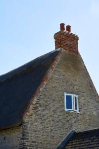 a brick building with a window on top of it at Dusk at The Sun Inn Felmersham in Sharnbrook