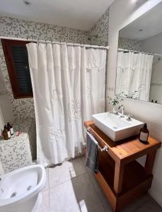 baño con lavabo y cortina de ducha en Casa Los Olivos en Nueve de Julio