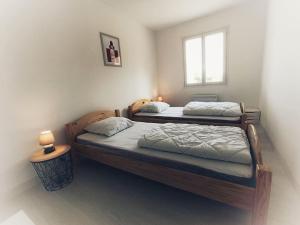 zwei Einzelbetten in einem Schlafzimmer mit Fenster in der Unterkunft Maison Mimosa avec jardin clos - plage à 500m in Chaucre