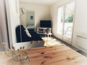 ein Wohnzimmer mit Sofa und Fernseher in der Unterkunft Maison Mimosa avec jardin clos - plage à 500m in Chaucre