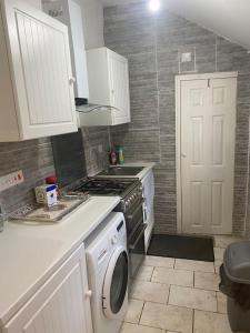 uma cozinha com um fogão e uma máquina de lavar roupa em Family-Friendly Home in Nottingham em Nottingham