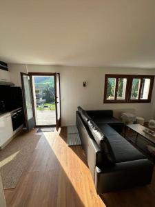 a living room with a black couch and a table at Chalet du Moléson in Gruyères