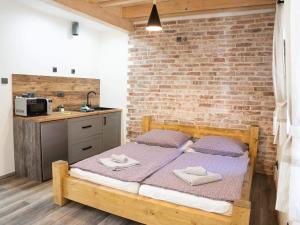 a bedroom with a bed and a brick wall at Penzion u Orloje in Žatec