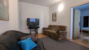 a living room with a couch and a television at Green Garden Group Accommodation in Osijek